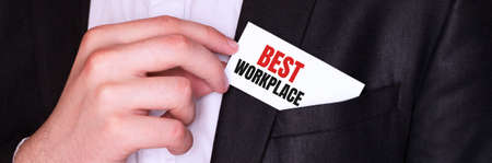 Businessman putting a card with text BEST WORKPLACE in the pocketの写真素材