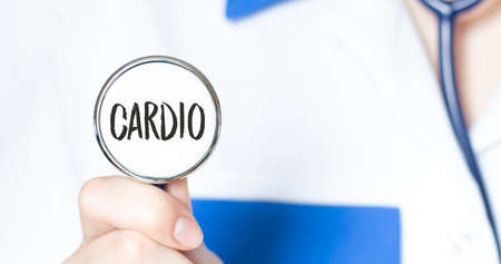 cardio text written in a stethoscope in doctor hands. Medical concept.