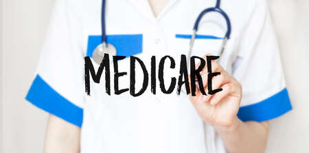 Doctor writing word MEDICARE with marker, Medical conceptの写真素材