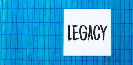 blank note pad with LEGACY text on blue wooden backgroundの写真素材