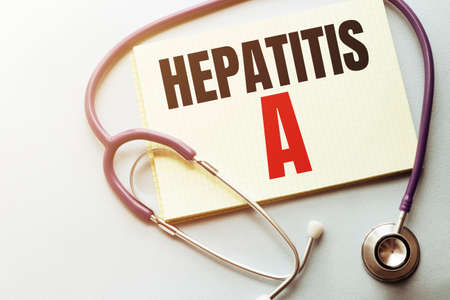 On a purple background a stethoscope and pen with yellow list with text HEPATITIS Aの写真素材