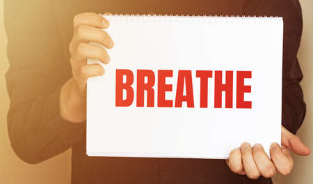 Man holding brochure with breathe text on grey background. Mock up for designの写真素材