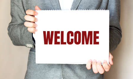 Businessman holding a paper sheet with text WELCOME