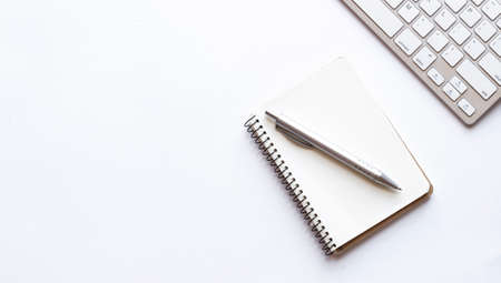 Notepad, keyboard and pen isolated on white backgroundの写真素材