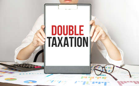 businesswoman holding a card with text DOUBLE TAXATIONの写真素材