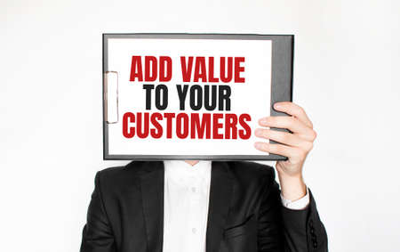 Show wait word on paper shown by business man isolated on white background. Text ADD VALUE TO YOUR CUSTOMERSの写真素材