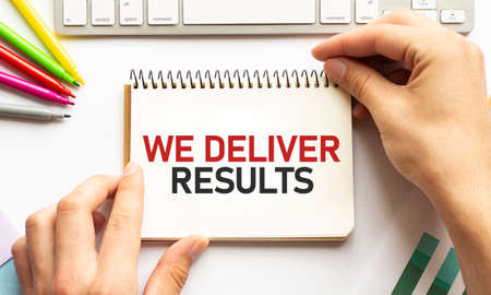 businesman hold notepad with text WE DELIVER RESULTS White background. Businessの写真素材