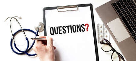 Doctor holding a card with text Questions medical conceptの写真素材