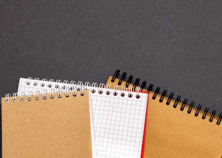 Top view of closed black cover notebook with pencil on white desk background