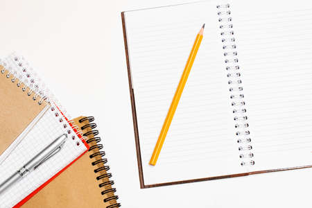 Top view of closed black cover notebook with pencil on white desk backgroundの写真素材
