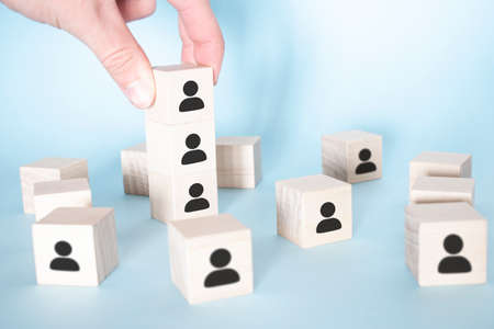 Wooden blocks with businessman icon on blue background, Organization structure, social network,...