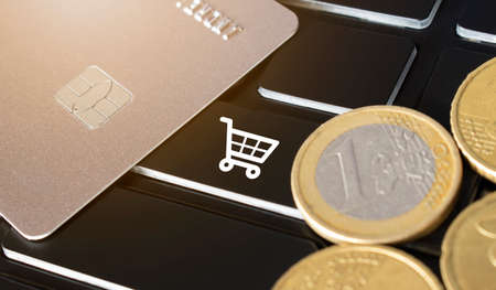 Credit card, coins and shopping card icon on the black keyboard. Online shopping concept