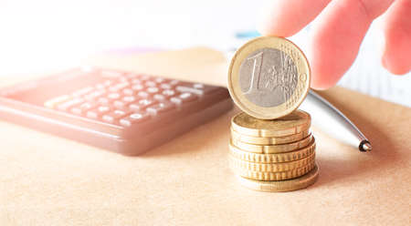 Business, finance or investment concept. Coins, check book or note book and fountain pen, calculator. White background. Copyspace for text.の写真素材