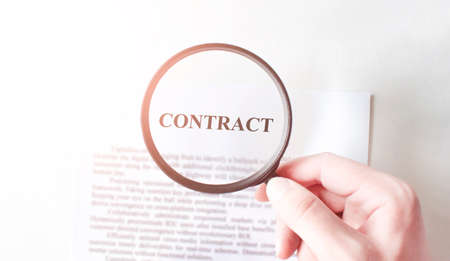 Contract with pen and magnifying glass. Business conceptの写真素材