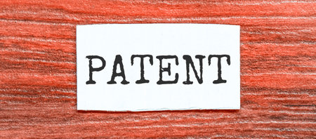 PATENT text on the piece of paper on the red wood backgroundの写真素材