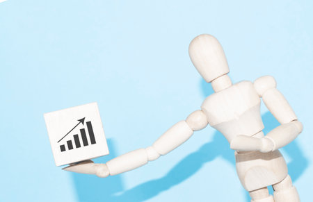 Business and design concept - wooden mannequin with surreal wood cube isolated on white background. the symbol of leadership, communication and successの写真素材