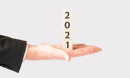 Business concept., Hand hold wooden cubes with 2021 word on white background with copy space for text.の写真素材