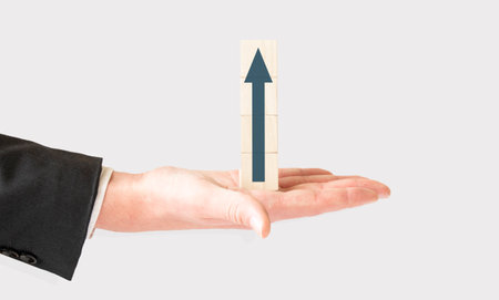 Business concept., Hand hold wooden cubes with finance arrow icon on white background with copy...