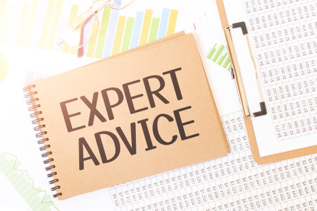 Business up graph on a sheet of craft color Notepad with EXPERT ADVICE sign. Notepad on desk with financial documentationの写真素材