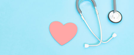 Health care check-up with red heart and Stethoscope on a blue background. Healing care concept and copy space. Above view of medical equipment for disease treatment on the blue backdrop.の写真素材