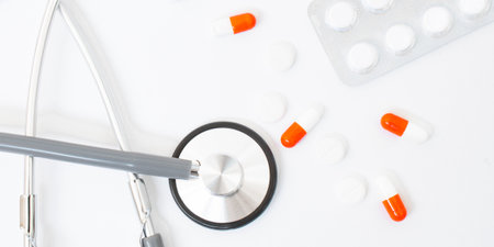 stethoscope, red heart sheet of paper for notes on a white background on the tableの写真素材