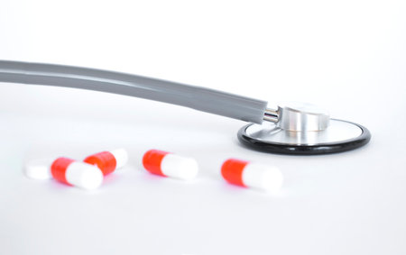 Creative medical postcard stethoscope, pills and red heart on white background. Medicine flatlay.の写真素材