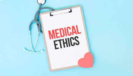 Gray stethoscope and paper plate with a sheet of white paper with text MEDICAL ETHICS light blue...