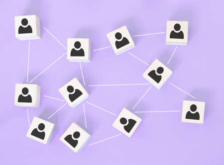 Organization structure, team building, business management or human resources concepts. Person icons on wooden cubes linked to each other.の写真素材