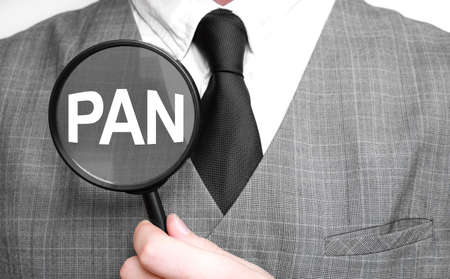 Businessman with magnifying glass on the white background. PAN signの写真素材