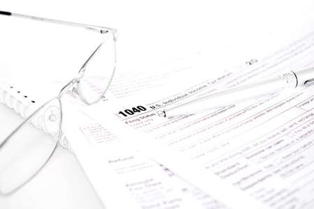 US tax form 1040 with a silver pen and glassesの写真素材