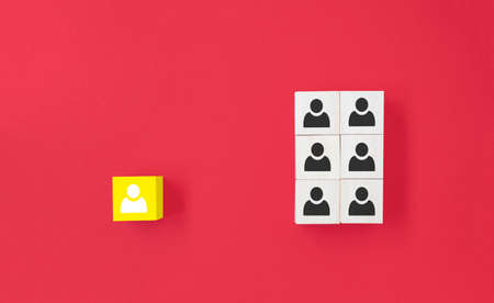Yellow wooden cube with person icon stand out from the crowd on blue background. Dissenting opinion, divergent views and different conceptsの写真素材