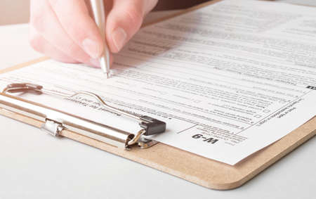business, office, school and education concept - man filling tax formの写真素材