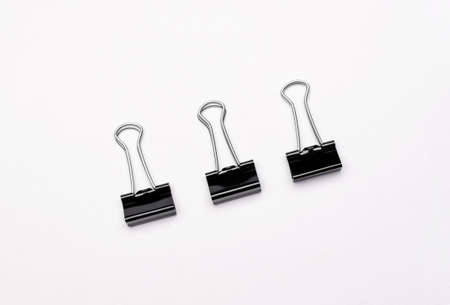 An image of black paper clips on whiteの写真素材