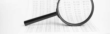 Business documents with magnifying glass, workplace businessman
