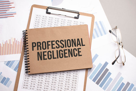 Notepad with text PROFESSIONAL NEGLIGENCE on a charts and numbers. Business concept.の写真素材