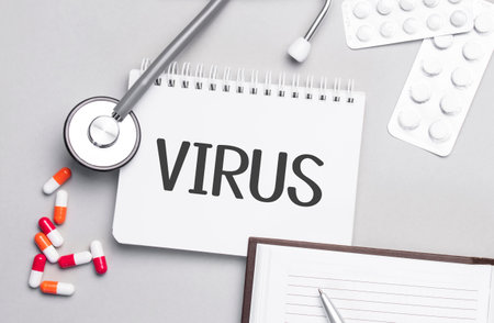 Stethoscope, pills and notebook with VIRUS text on the medical table.の写真素材