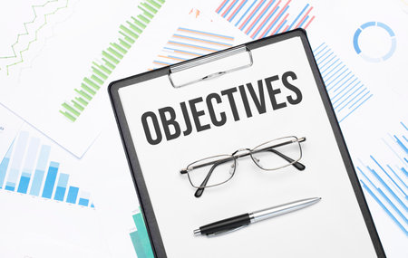 OBJECTIVES sign. Conceptual background with chart, papers, pen and glasses