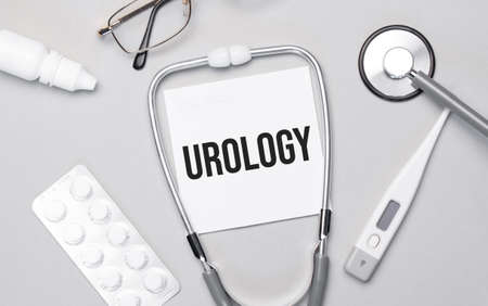 In the notebook is the text UROLOGY, stethoscope, pills, and glasses.の写真素材