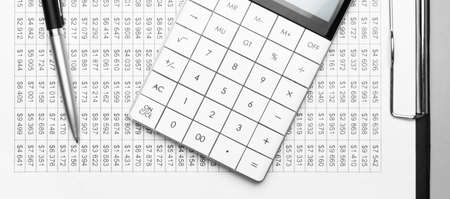 A calculator and pen on financial papers