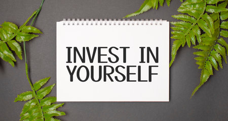 INVEST IN YOURSELF text with real leaves tropical jungle background.flat lay design.の写真素材