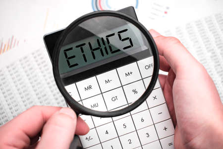 The word ETHICS is written on the calculator. Business man holding a calculator in his hand.の写真素材