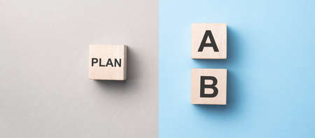 Hand choose wooden cube with the word PLAN A to PLAN B on blue and yellow background. Business...