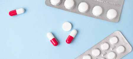 Antibiotics bi color capsules over blue background.の写真素材