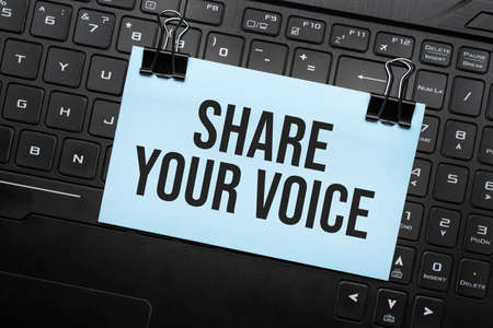 SHARE YOUR VOICE inscription on white paper note on laptop keyboard. Closeup message.の写真素材
