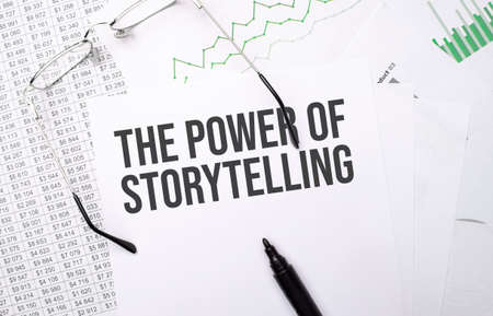 THE POWER OF STORYTELLING. Conceptual background with chart, papers, pen and glassesの写真素材