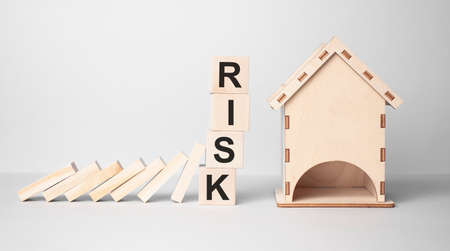 Red RISK cube blocks stop falling blocks protect house miniature. fall Business, Home Insurance, investment, Crisis, Economic recessionの写真素材