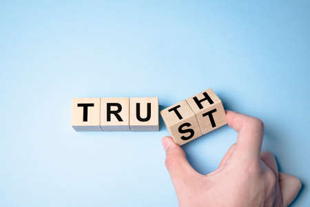 Truth instead of trust. Hand turns dice and changes the word Trust to Truth.の写真素材
