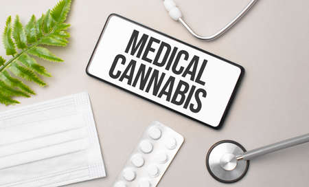 MEDICAL CANNABIS word on smartphone, stethoscope and green plantの写真素材
