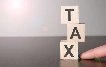 Businesswoman made word tax with wood building blocks.の写真素材