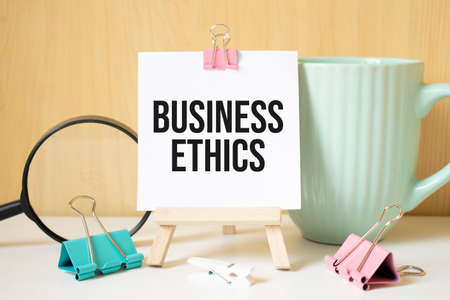 business ethics text written on black notebook with magnifying glass and a pen. Business and achievement concept.の写真素材